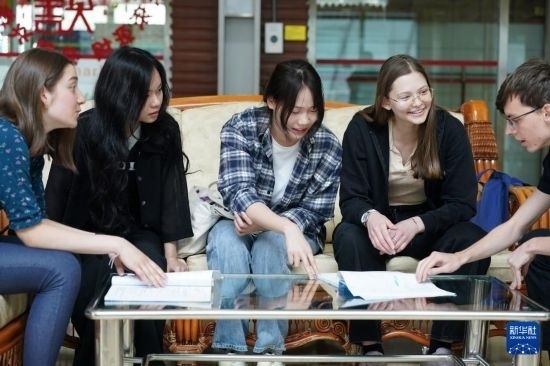 4月28日，宋智孝（右二）和胡靈月（左一）在北京首都師范大學校園內與同學交流。新華社記者 彭子洋 攝