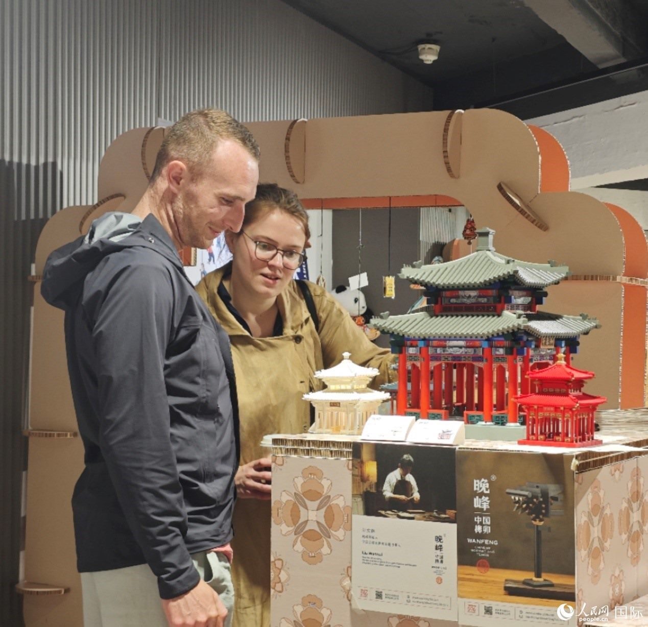 英國觀眾在欣賞中國傳統(tǒng)榫卯結構建筑模型。邢雪攝