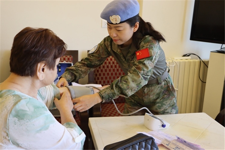 【1】 醫(yī)療分隊隊員為當?shù)鼗颊邷y量血壓。曾德樂攝