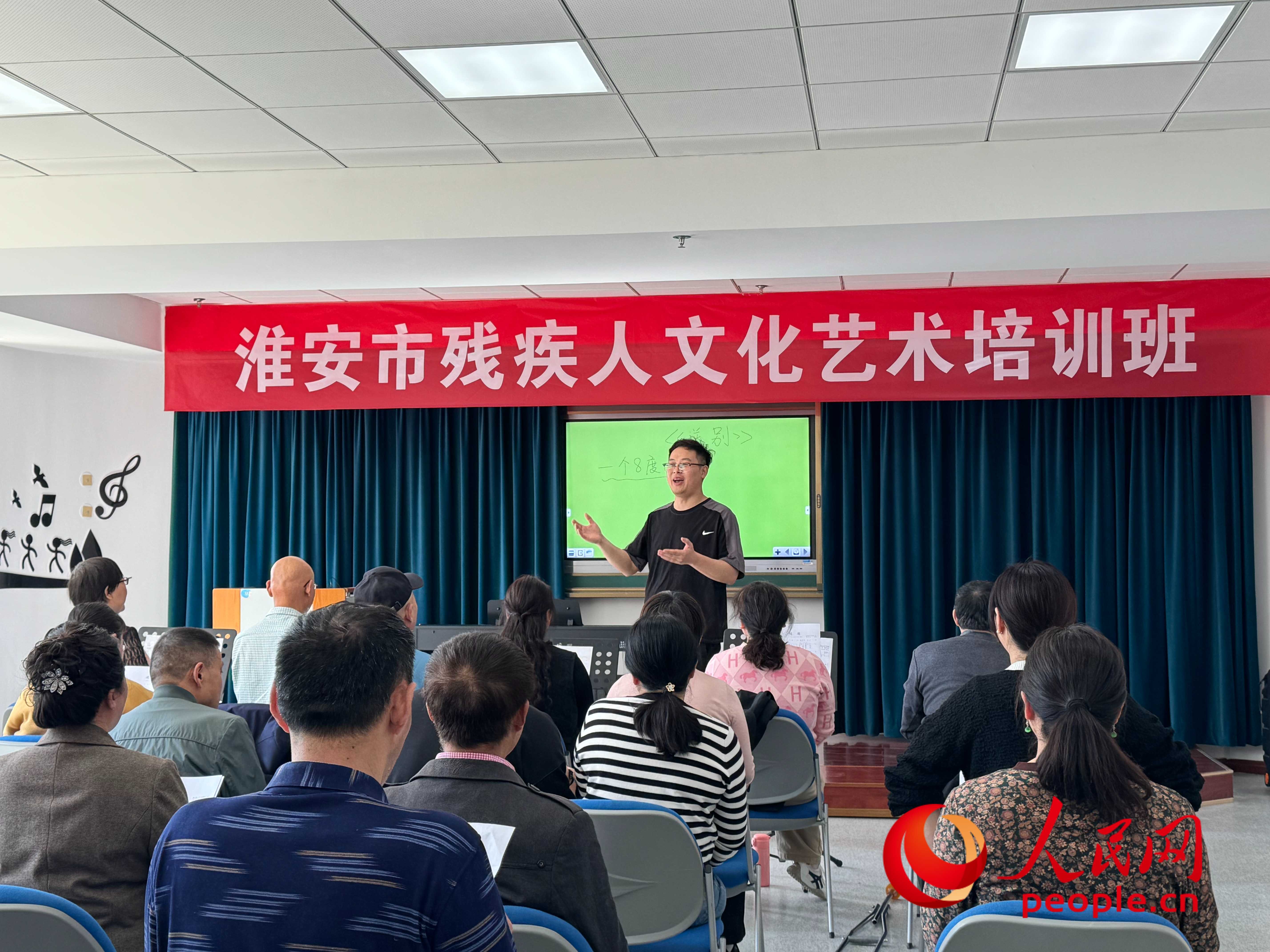 在淮安市殘疾人文化藝術(shù)培訓(xùn)班上，聲樂老師在教殘疾人唱《送別》這首歌曲。人民網(wǎng) 周靜圓攝