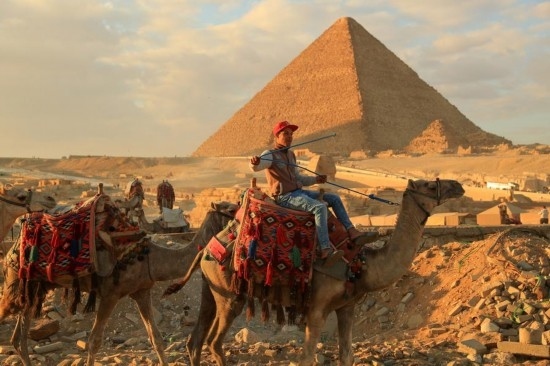 1月24日，商販騎駱駝離開埃及吉薩金字塔景區(qū)。新華社記者 隋先凱 攝
