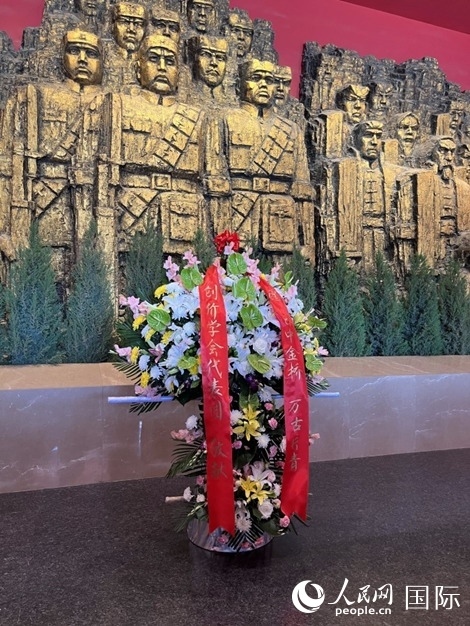 創(chuàng)價學(xué)會青年代表團(tuán)敬獻(xiàn)的花籃上，寫有“愿日中金橋萬古長青”。人民網(wǎng)記者 陳思攝