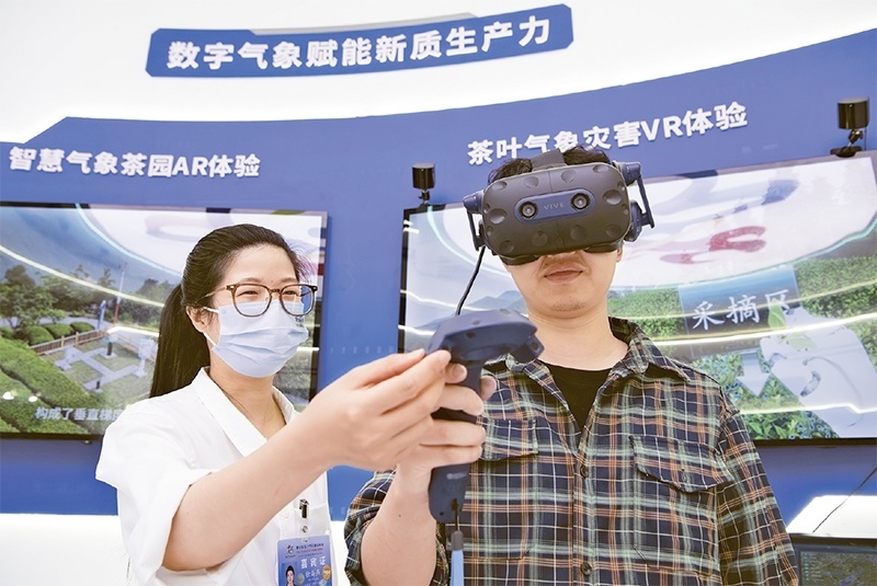 2024年5月23日，第七屆數(shù)字中國建設峰會現(xiàn)場體驗區(qū)在福州海峽國際會展中心向專業(yè)觀眾開放。本次現(xiàn)場體驗區(qū)圍繞本屆峰會主題“釋放數(shù)據要素價值，發(fā)展新質生產力”，設置“數(shù)字惠民”、“數(shù)字能力”、“數(shù)字基礎”、“數(shù)字生態(tài)”、“數(shù)字賦能”五大板塊。圖為一名觀眾（右）在數(shù)字氣象賦能新質生產力展臺上進行體驗。 新華社記者 魏培全/攝