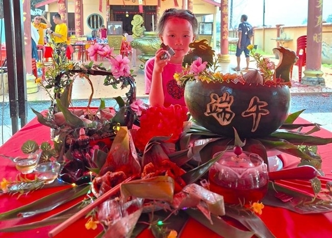 小朋友展示學(xué)裹粽子的成品照。組委會(huì)供圖