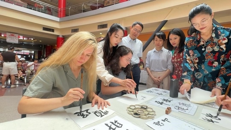 羅馬尼亞友人在活動現(xiàn)場學(xué)寫漢字。中國駐羅馬尼亞大使館領(lǐng)僑處供圖