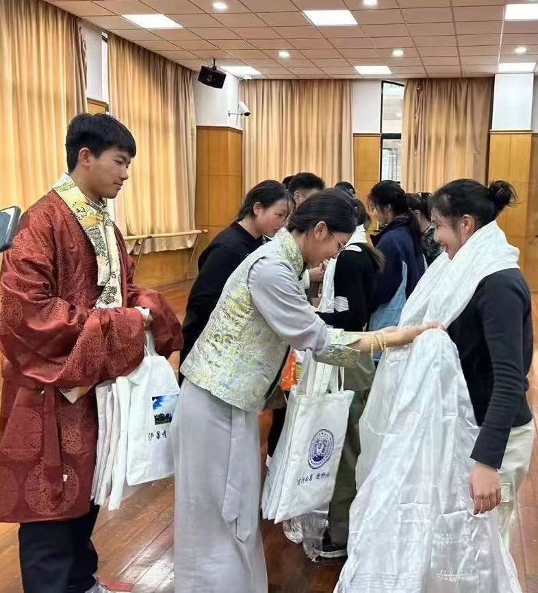 2024年1月18日，在上海市大同中學(xué)，果洛西寧民族中學(xué)學(xué)生給上海大同中學(xué)師生獻哈達。新華社發(fā)（果洛州教育局供圖）