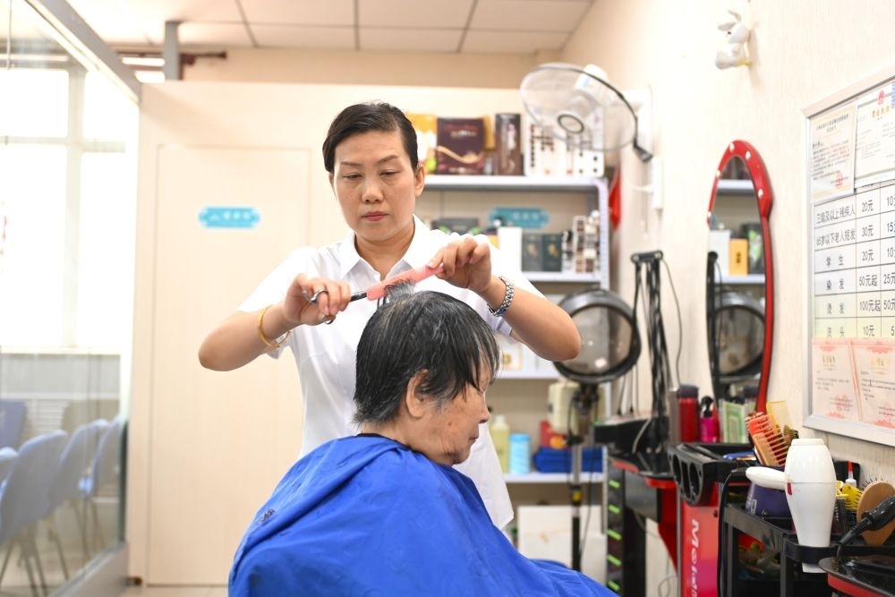 6月20日，長(zhǎng)城花園社區(qū)的志愿者為居民理發(fā)。