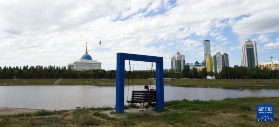 6月30日，一名女子在哈薩克斯坦首都阿斯塔納伊希姆河畔休息。新華社記者 王建華 攝