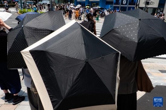 7月4日，人們?cè)谌毡緰|京原宿的街道上等待紅綠燈。新華社記者 張笑宇 攝