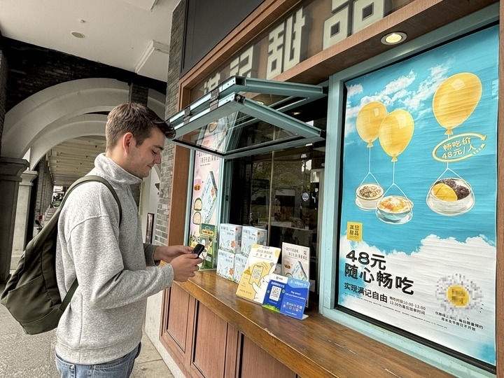 來自德國的留學生理查德在杭州西湖邊一家商鋪使用支付寶掃碼支付（2024年4月11日攝）。新華社發(fā)