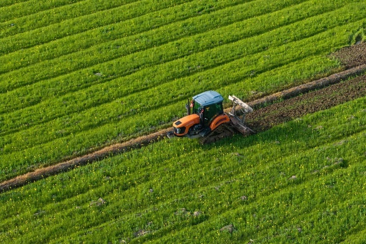 2024年3月19日，在湖南省常德市鼎城區(qū)謝家鋪鎮(zhèn)港中坪村，村民駕駛農(nóng)機(jī)翻耕田地（無(wú)人機(jī)照片）。新華社記者 陳思汗 攝