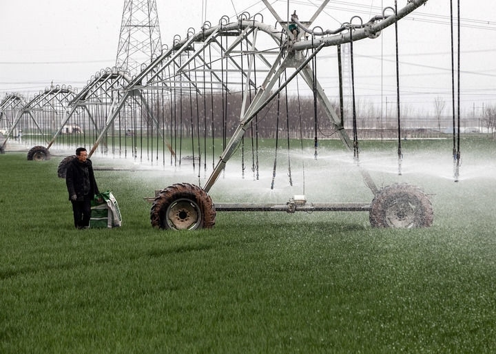 2024年3月18日，在河南省焦作市博愛(ài)縣孝敬鎮(zhèn)東原莊村瑞輝家庭農(nóng)場(chǎng)，村民使用全自動(dòng)指針式噴灌機(jī)進(jìn)行澆灌作業(yè)。新華社發(fā)（程全攝）
