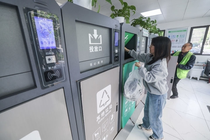 2024年4月10日，在浙江省湖州市吳興區(qū)飛英街道新華府小區(qū)內(nèi)，居民在垃圾分類智能系統(tǒng)的指導(dǎo)下進(jìn)行垃圾分類投放，居民的投放情況將實(shí)時(shí)匯總到智慧服務(wù)平臺(tái)，會(huì)有相應(yīng)的積分獎(jiǎng)勵(lì)。新華社記者 徐昱 攝