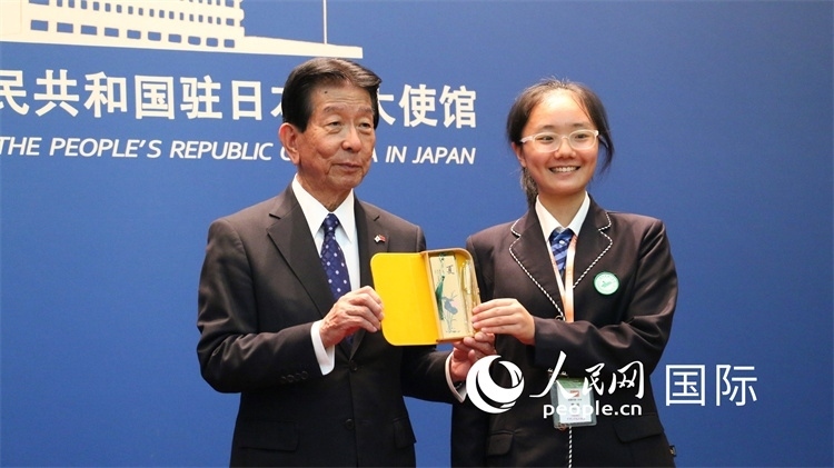 中國小大使向日本永旺1%俱樂部理事長森美樹贈送當?shù)靥厣Y品。人民網 許可攝