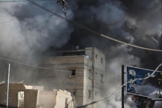 7月21日，在加沙地帶中部的努賽賴特難民營，遭以軍空襲的建筑冒出滾滾濃煙。新華社發(fā)（馬爾萬·達烏德攝）