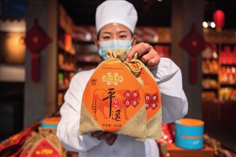 在位于山西省晉中市平遙縣的平遙古城南大街的一家平遙牛肉店內(nèi)，工作人員展示一款牛肉產(chǎn)品（資料照片）楊晨光攝 / 本刊