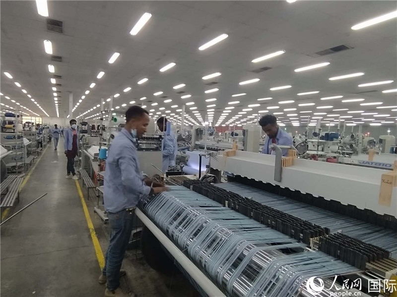 無(wú)錫金茂埃塞面料廠車間內(nèi)，當(dāng)?shù)毓と苏谝唤z不茍地作業(yè)。人民網(wǎng)記者 黃培昭攝