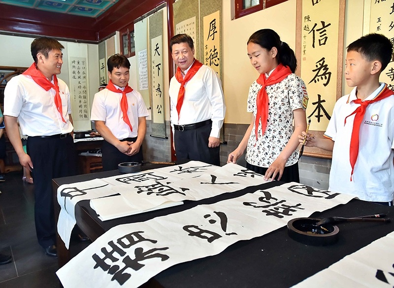 2014年5月30日，習(xí)近平總書記來到北京市海淀區(qū)民族小學(xué)，參加慶?！傲弧眹H兒童節(jié)活動。這是總書記觀看學(xué)生書寫的毛筆字。