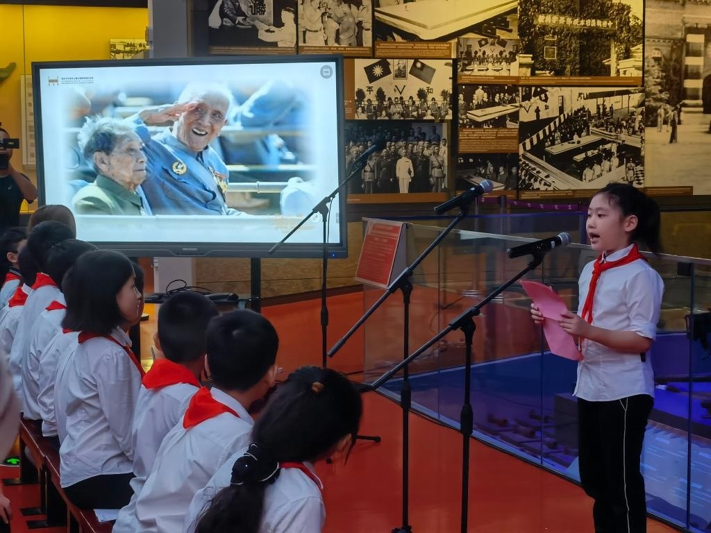 南京市科睿小學(xué)二年級(jí)學(xué)生章若初為大家講述抗戰(zhàn)老兵手印的故事。 新華社記者 邱冰清 攝