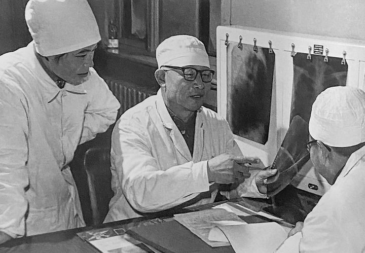 1980年1月16日，中日友好醫(yī)院首任院長辛育齡（中）在內(nèi)蒙古結(jié)核病院與胸外科醫(yī)師討論病例（翻拍照片）。 新華社發(fā)