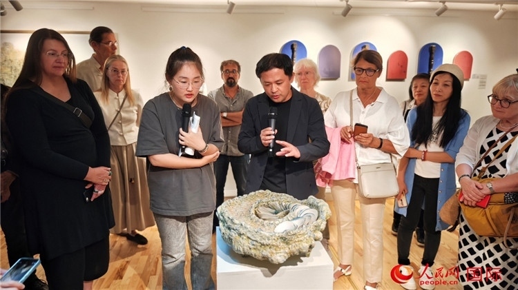 參展人、景德鎮(zhèn)陶瓷大學設計藝術學院副院長余劍峰（中）向來賓介紹參展作品。人民網記者 殷淼攝