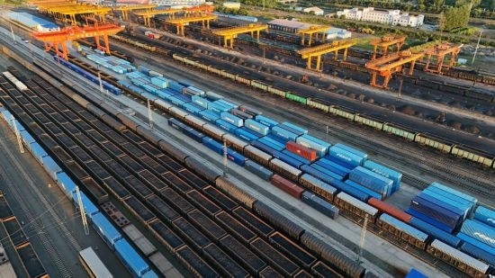 這是2024年8月14日在黑龍江綏芬河鐵路口岸集裝箱換裝場拍攝的集裝箱換裝作業(yè)現(xiàn)場（無人機照片）。今年前七個月，綏芬河鐵路口岸開行中歐班列573列，運量達55246標箱，同比分別增長23%和18%，班列數(shù)量持續(xù)保持高位運行。