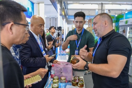 2023年8月23日，在第十四屆中國—東北亞博覽會東北亞商品館，俄羅斯參展商向參觀者介紹商品。