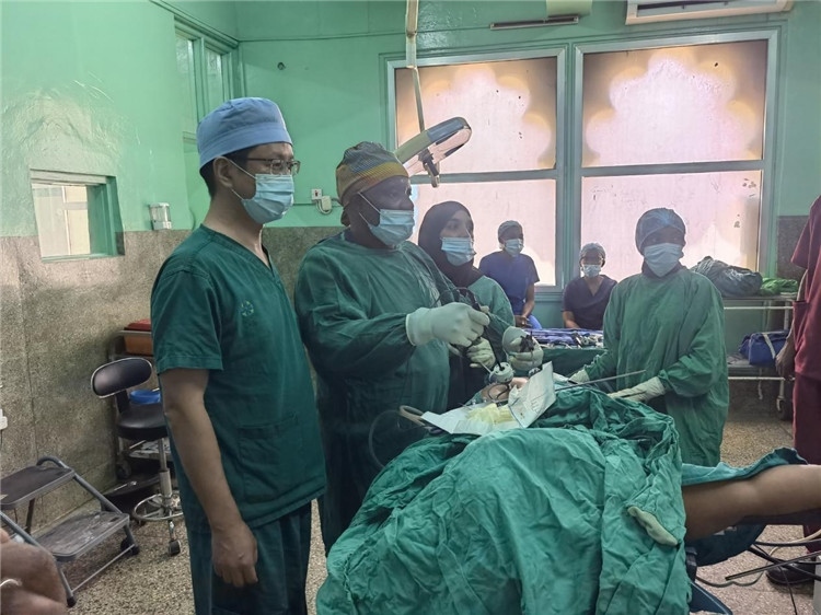 隊長蔣國慶（左一）關(guān)注當(dāng)?shù)蒯t(yī)生手術(shù)情況。中國援桑醫(yī)療隊供圖