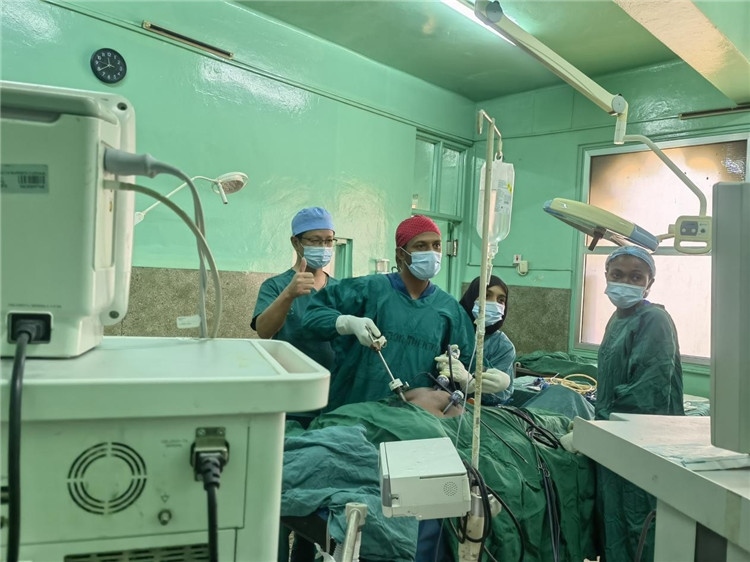 隊長蔣國慶（左一）關(guān)注當(dāng)?shù)蒯t(yī)生手術(shù)情況。中國援桑醫(yī)療隊供圖