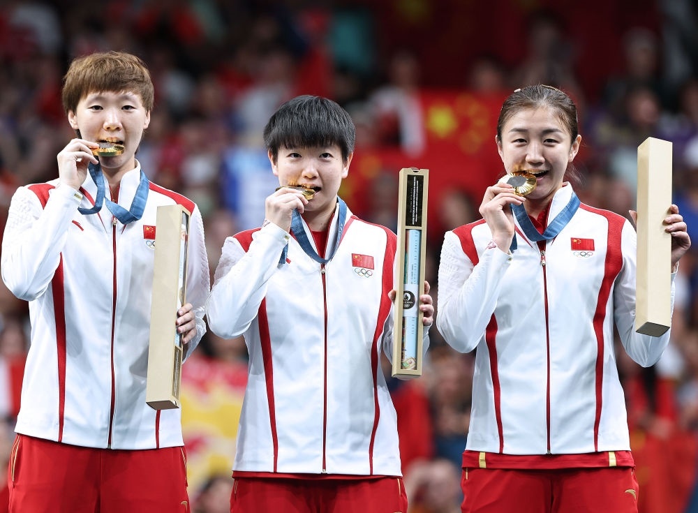冠軍中國隊選手王曼昱、孫穎莎、陳夢（從左至右）在巴黎奧運會乒乓球女子團體頒獎儀式上（2024年8月10日攝）。新華社記者 王東震 攝