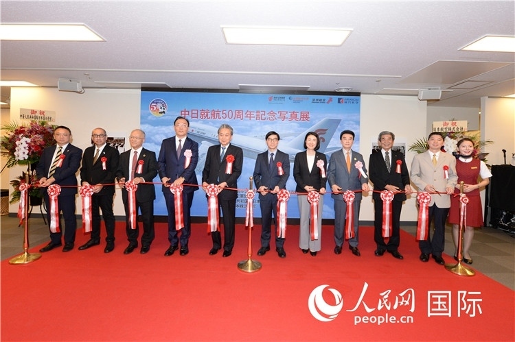 與會嘉賓共同為中日通航50周年紀(jì)念圖片展開幕剪彩。馮學(xué)敏攝