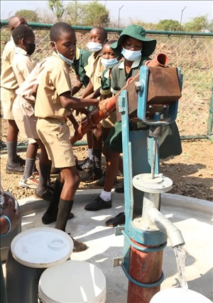 △2021年11月，在津巴布韋南馬塔貝萊蘭省省會關達的塞農(nóng)多小學，學生從中國援建水井里打水。