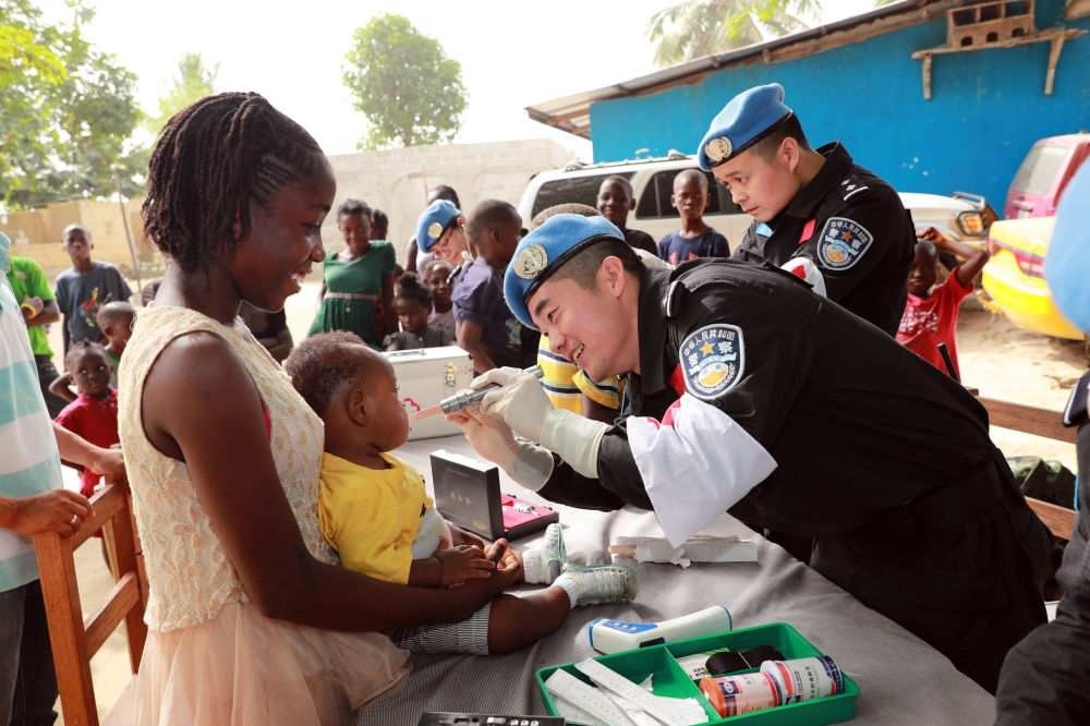 2017年12月28日，在利比里亞蒙羅維亞，中國維和警察防暴隊醫(yī)療人員為兒童做口腔檢查。