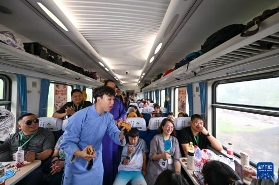 9月7日，相聲演員在S910列車上為旅客表演快板。
