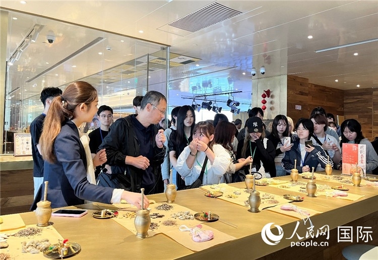 1. 日中友好協會青年代表團一行學習中醫(yī)香囊制作工序。（人民網記者陳思 攝）