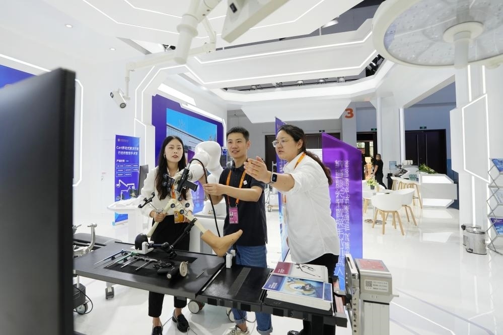 9月11日，一位媒體記者（中）在2024年服貿(mào)會國家會議中心會場體驗北京納通科技集團(tuán)有限公司的膝關(guān)節(jié)置換手術(shù)機(jī)器人。新華社記者鞠煥宗 攝