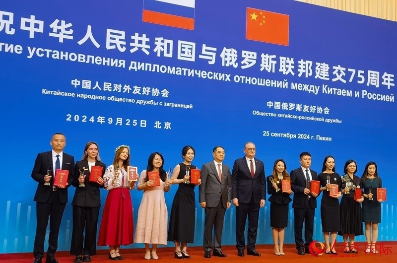 楊萬(wàn)明會(huì)長(zhǎng)和莫爾古洛夫大使為10位中俄青年友好微視頻創(chuàng)意大賽獲獎(jiǎng)代表頒獎(jiǎng)。人民網(wǎng)記者 李明琪攝