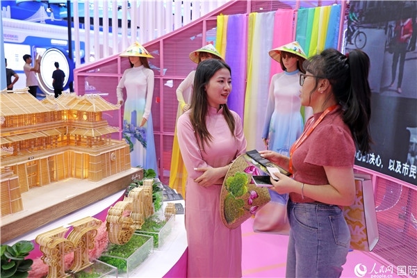 參觀者在東博會越南展區(qū)同工作人員咨詢交談。人民網(wǎng)記者 趙益普攝