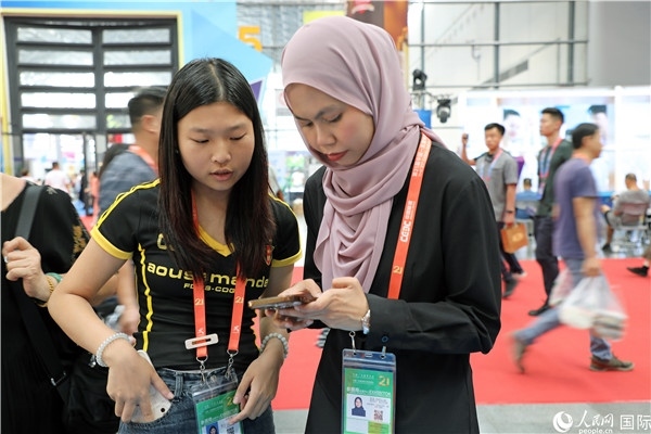 東博會現(xiàn)場，馬來西亞展商在同中方工作人員交談。人民網(wǎng)記者 趙益普攝