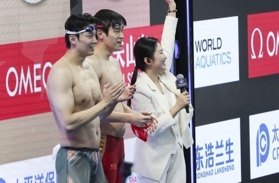  10月18日，汪順（左）和潘展樂在男子100米混合泳決賽后。新華社記者 方喆 攝