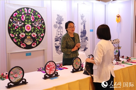 青海非遺文化傳承人向嘉賓介紹展品。人民網(wǎng)實習(xí)生姚欣可攝