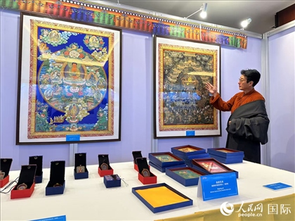 熱貢藝術(shù)國家級代表性傳承人夏吾角向嘉賓介紹作品。人民網(wǎng)記者 簡承淵攝