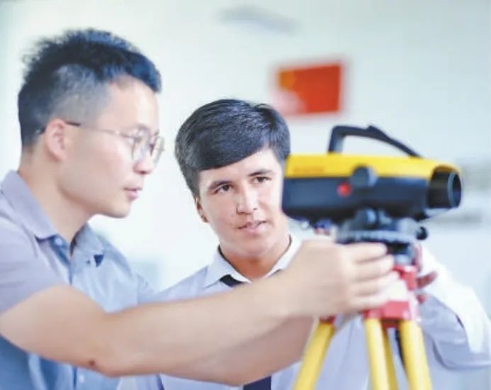 在塔吉克斯坦首都杜尚別的魯班工坊，來自天津城市建設(shè)管理職業(yè)技術(shù)學(xué)院的老師（左）為當(dāng)?shù)貙W(xué)生提供指導(dǎo)。新華社記者 鄭開君 攝