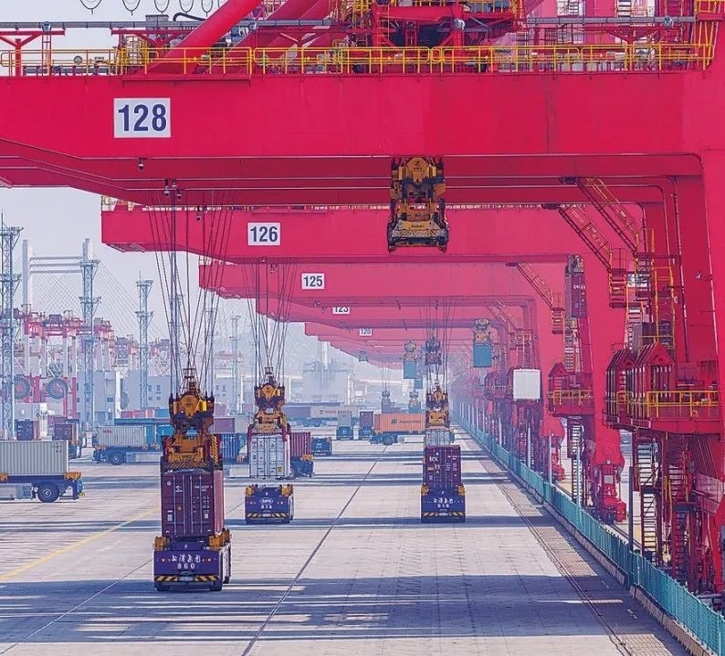 共建“一帶一路”國家在工作制度對(duì)接、技術(shù)標(biāo)準(zhǔn)協(xié)調(diào)、檢驗(yàn)結(jié)果互認(rèn)等方面強(qiáng)化合作、統(tǒng)一標(biāo)準(zhǔn)，貿(mào)易自由化便利化水平不斷提升。上海洋山港海關(guān)對(duì)接共建國家進(jìn)出口貨物相關(guān)標(biāo)準(zhǔn)，推動(dòng)通關(guān)一體化方式申報(bào)，提升通關(guān)效率。圖為無人駕駛的全自動(dòng)導(dǎo)引車在洋山港穿梭往來，搬運(yùn)集裝箱。王初 攝