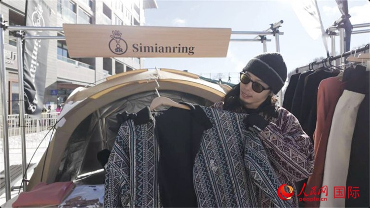 藤田周正在展示自己設(shè)計的滑雪服。人民網(wǎng)記者 袁蒙攝