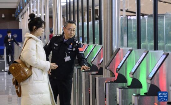 1月2日，大興機(jī)場邊檢站警察指導(dǎo)旅客使用自助出境設(shè)備。新華社記者 李欣 攝