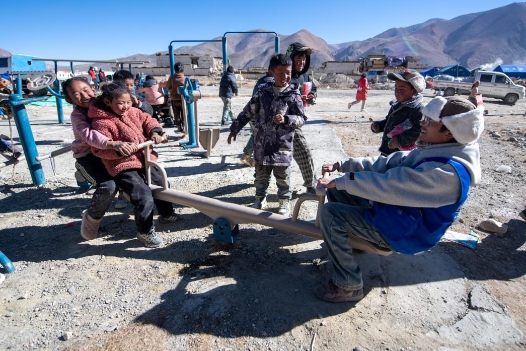 1月11日，在定日縣措果鄉(xiāng)塘仁村安置點(diǎn)，西藏星光社會(huì)工作服務(wù)中心志愿者和孩子們一起玩耍，進(jìn)行災(zāi)后心理疏導(dǎo)。人民網(wǎng)記者 翁奇羽攝