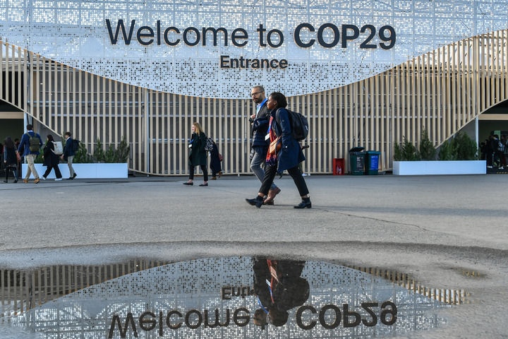 2024年11月15日，在阿塞拜疆首都巴庫，人們經(jīng)過聯(lián)合國氣候變化巴庫大會的會場。新華社記者 曹陽 攝