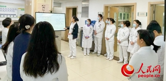 華西第四醫(yī)院姑息醫(yī)學科交班會上，護士介紹患者情況。人民網(wǎng)記者 金慧慧攝