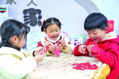 圖為孩子們?cè)诶蠋熤笇?dǎo)下制作蛇年主題剪紙。 新華社記者 徐昱攝